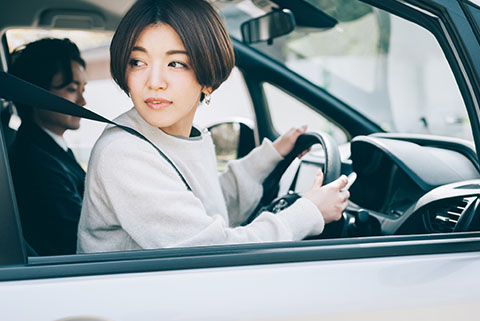 駐車場に入庫する女性
