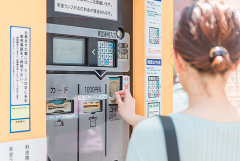 駐車場の出庫精算をする女性