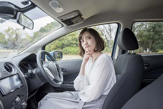 運転席で考え事をする女性