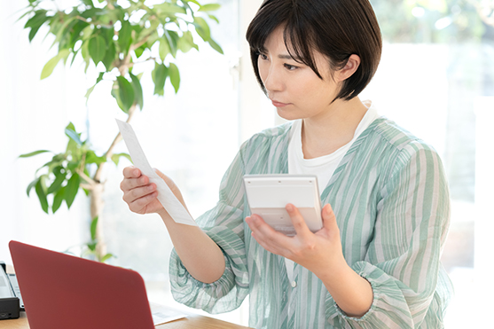 書類と電卓を見比べる女性