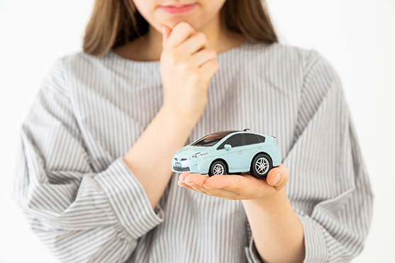 車の模型を持った若い女性